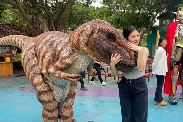 Dinosaur costumes interact with visitors at scenic spots.jpg